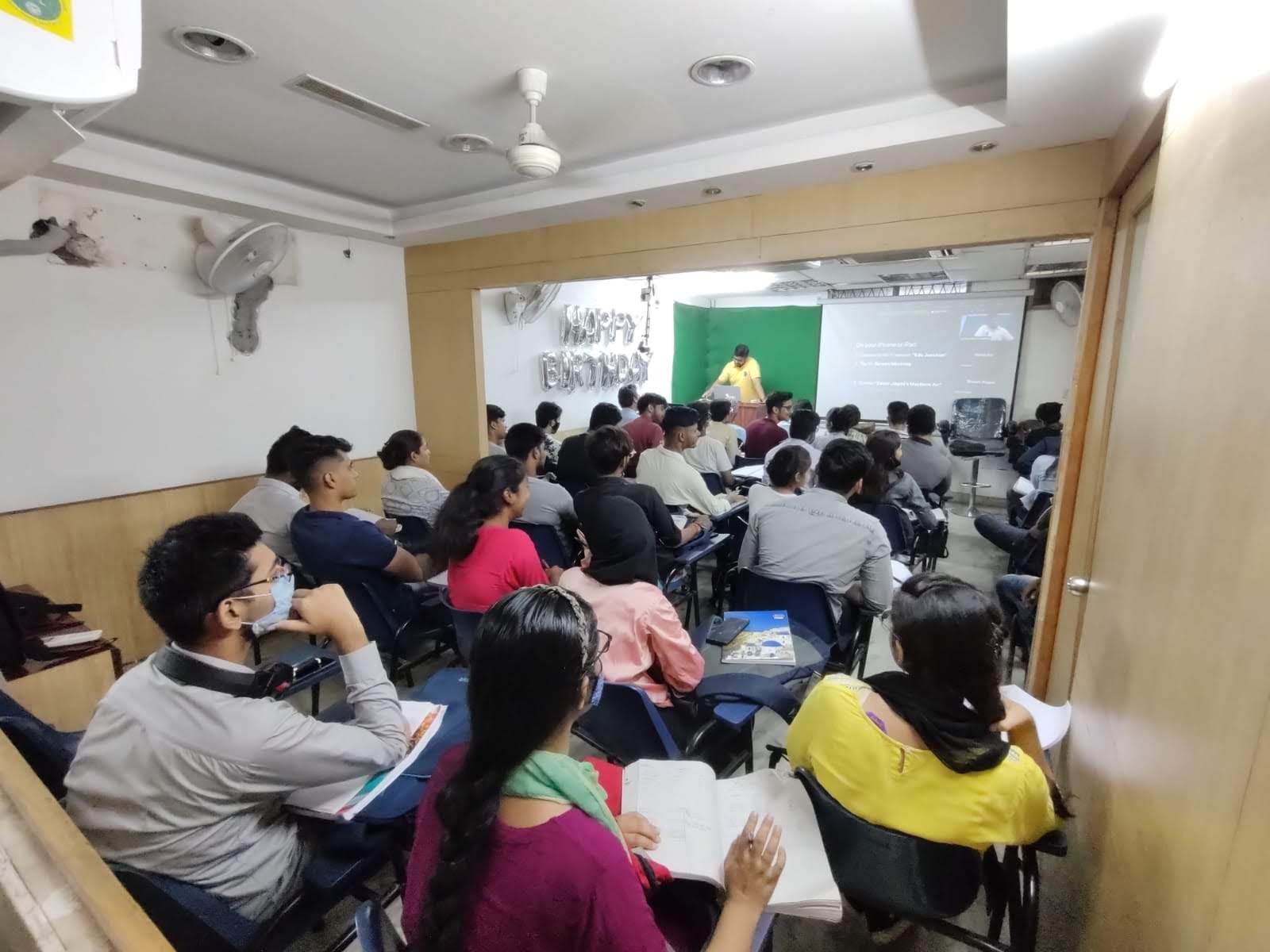 Faculty delivering a lecture with projector support