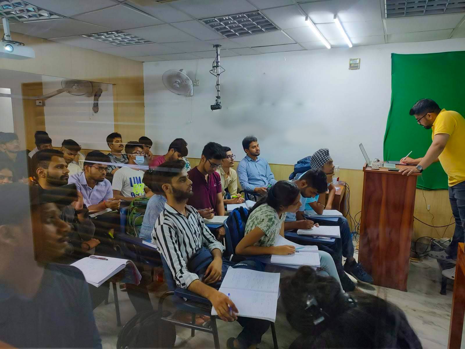 Teacher explaining concepts at the podium in a small batch